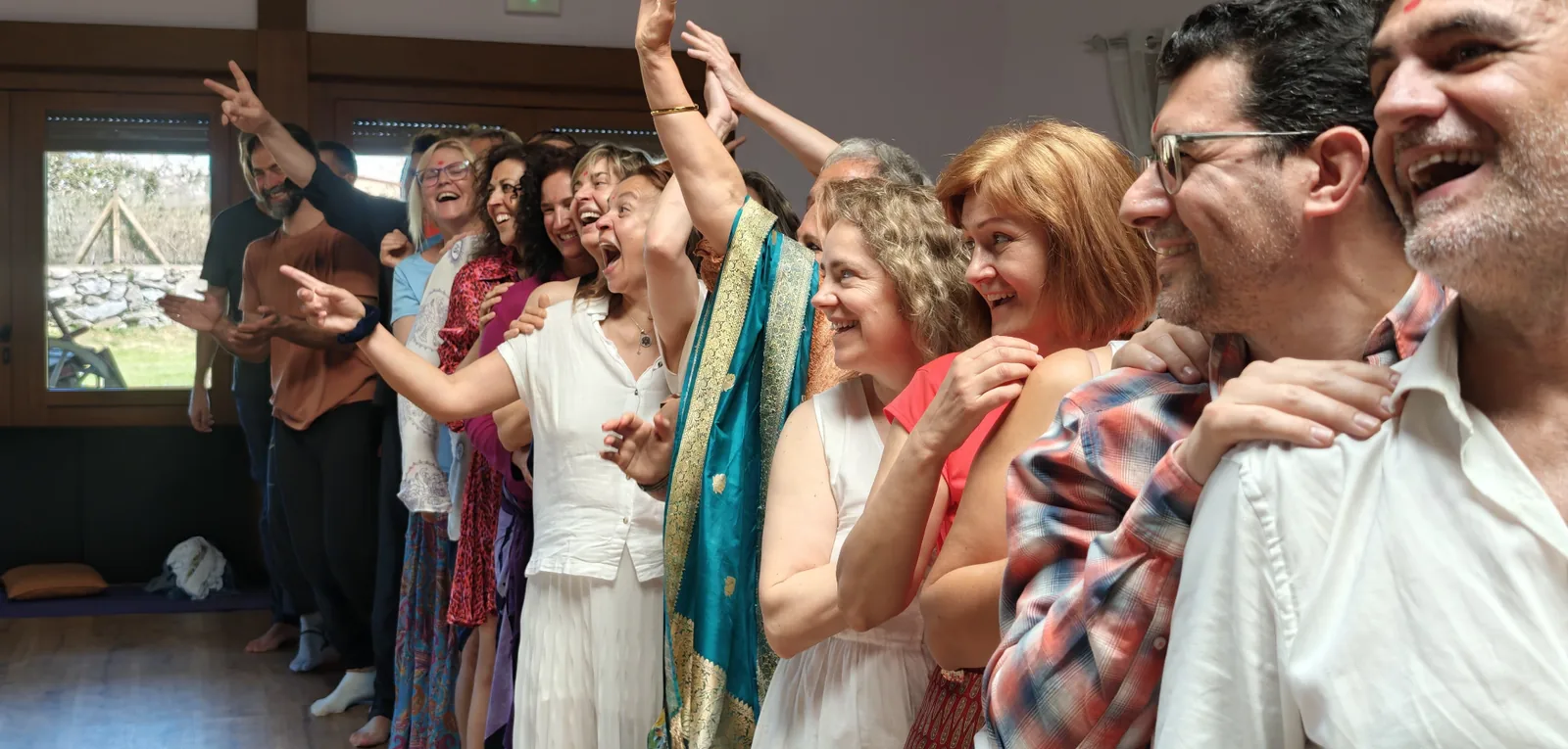 Grupo bailando y celebrando con alegría en un retiro de relaciones conscientes