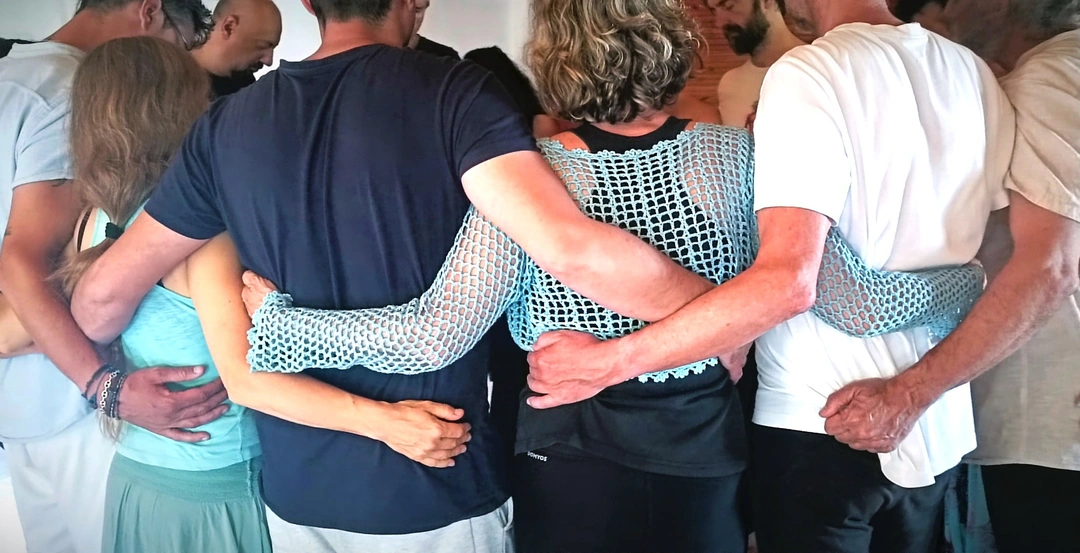 Abrazo grupal en círculo durante una sesión de biodanza