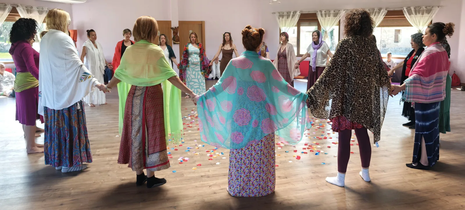 Círculo de mujeres cogidas de las manos en una sesión de biodanza