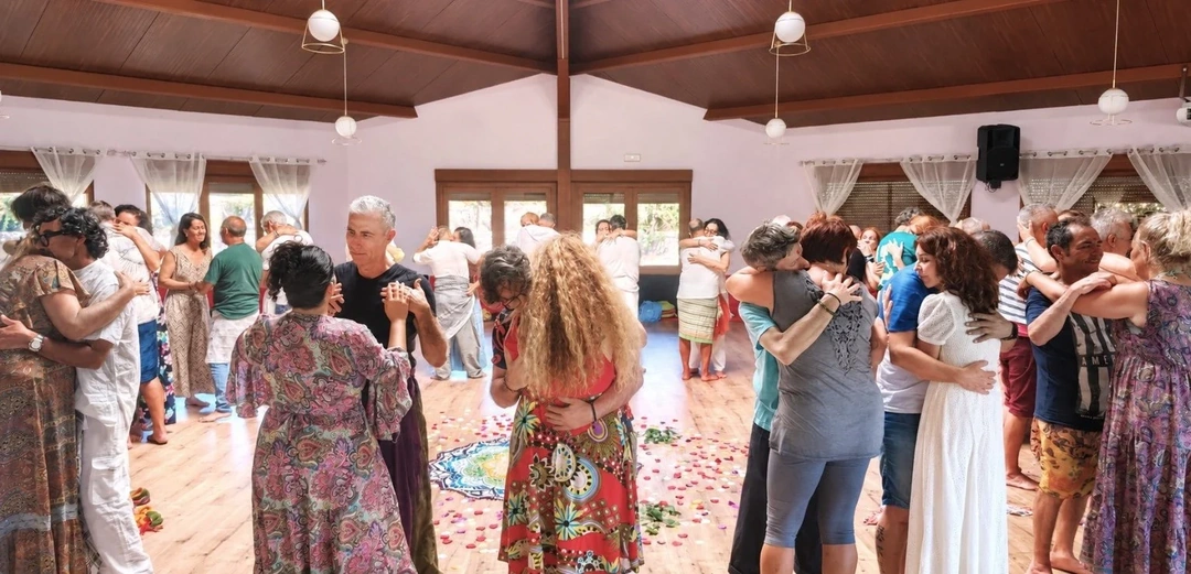 Participantes abrazándose por parejas durante un taller de Tantra del Corazón.